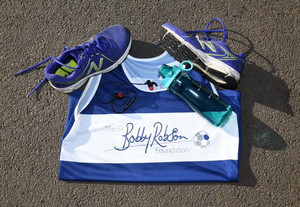 Sir Bobby Robson Foundation running vest with trainers, water bottle and headphones